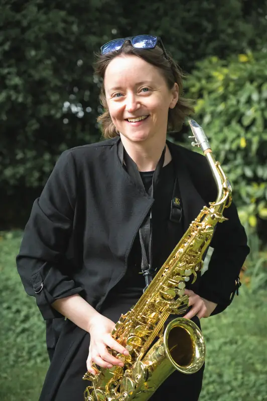 Portrait of a saxophone player looking slightly awkward after being asked to pose