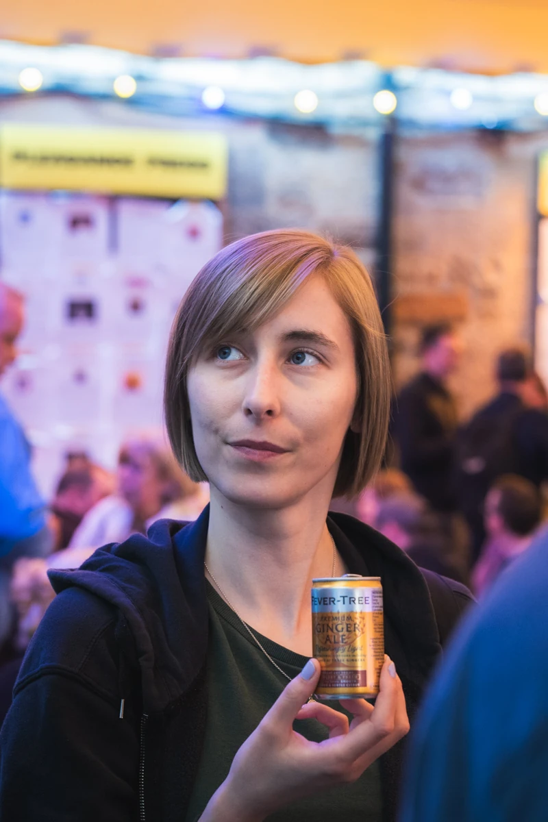 A woman holding up a can of ginger ale