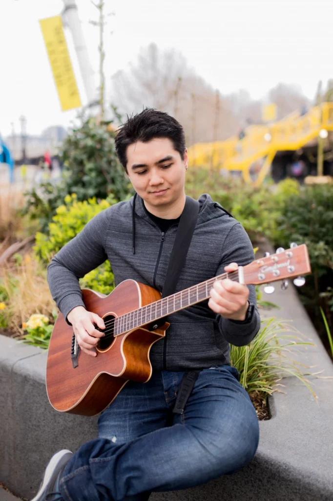 Tommy McDevitt playing the guitar outdoors